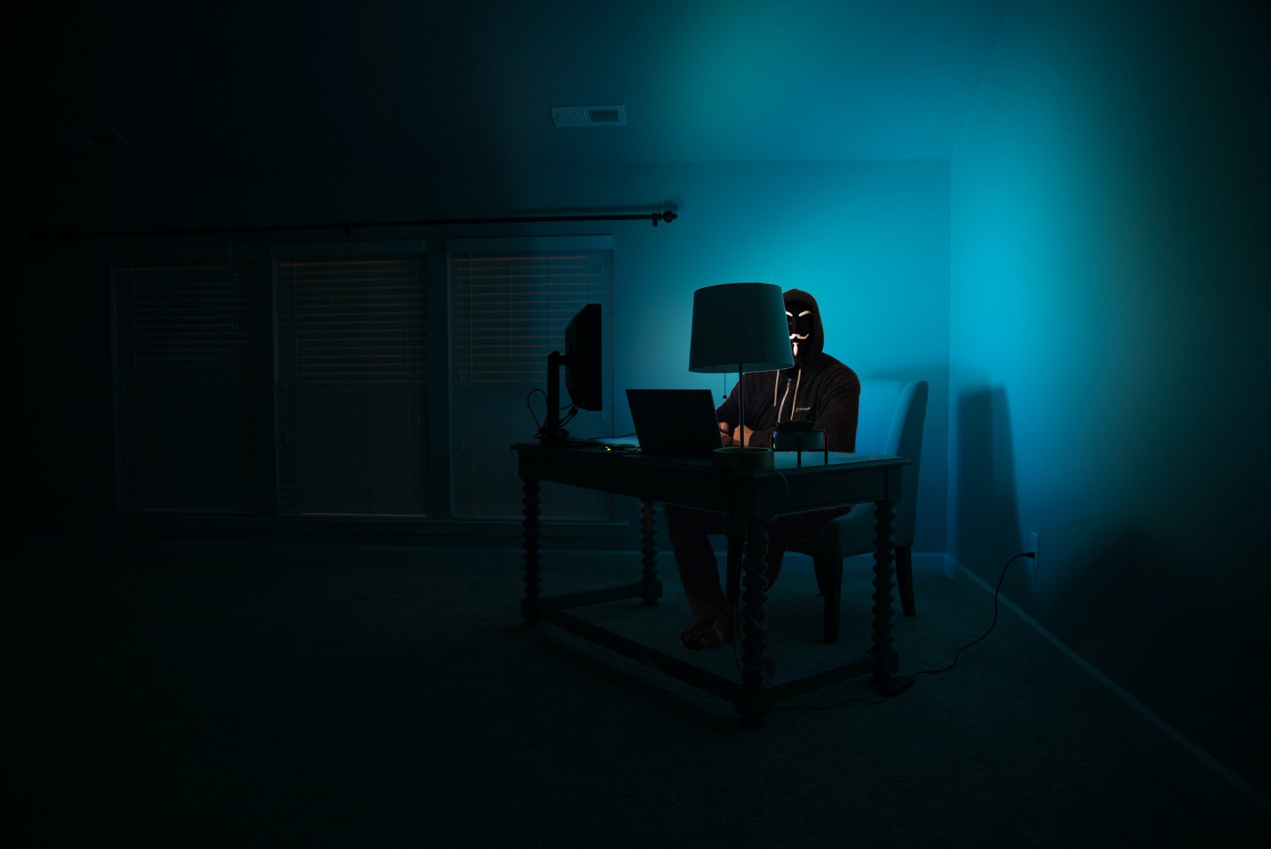 imagen de hombre en cuarto oscuro sentado en computadora