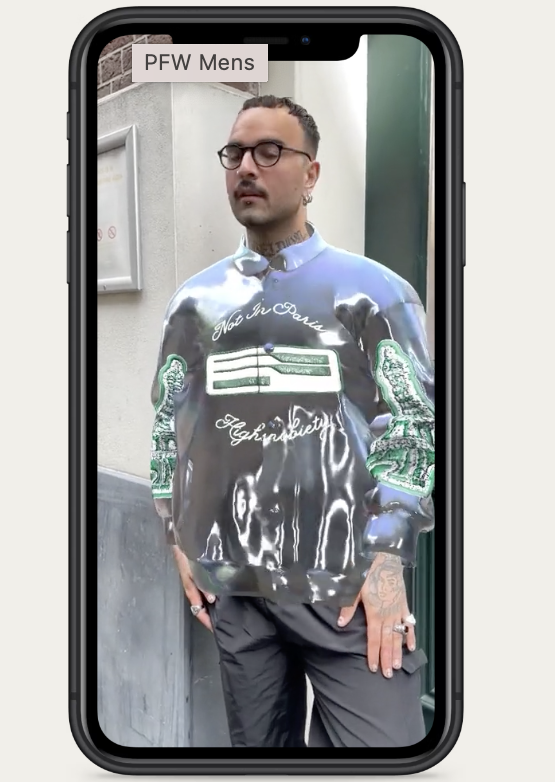 imagen de un hombre que usa una chaqueta Varsity digital portátil a través de AR en un teléfono inteligente