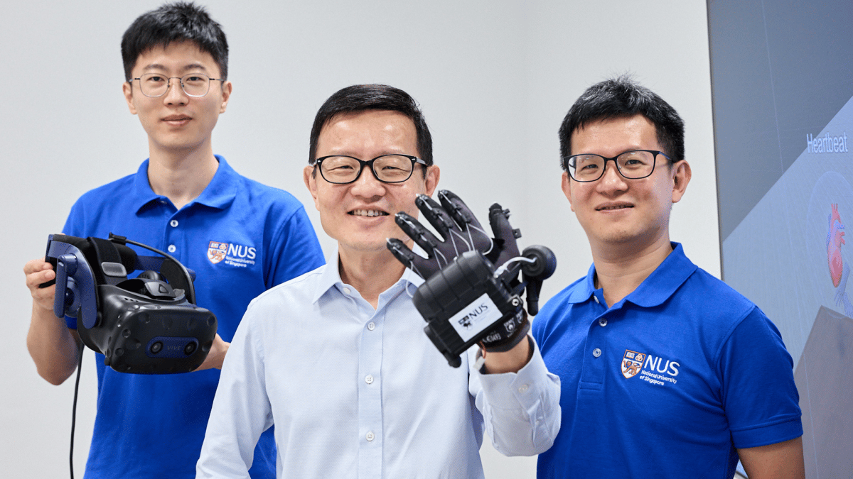 Tres hombres se paran ante un fondo blanco en apoyo de The University of Singapore VR Glove.